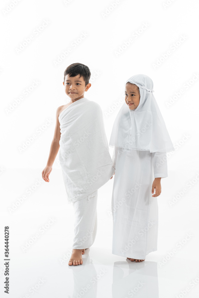 cute little kid wearing muslim ihram clothes and dress holding hand and walk. hajj and umrah concept cute little kid wearing muslim ihram clothes and dress holding hand and walk. hajj and umrah concept