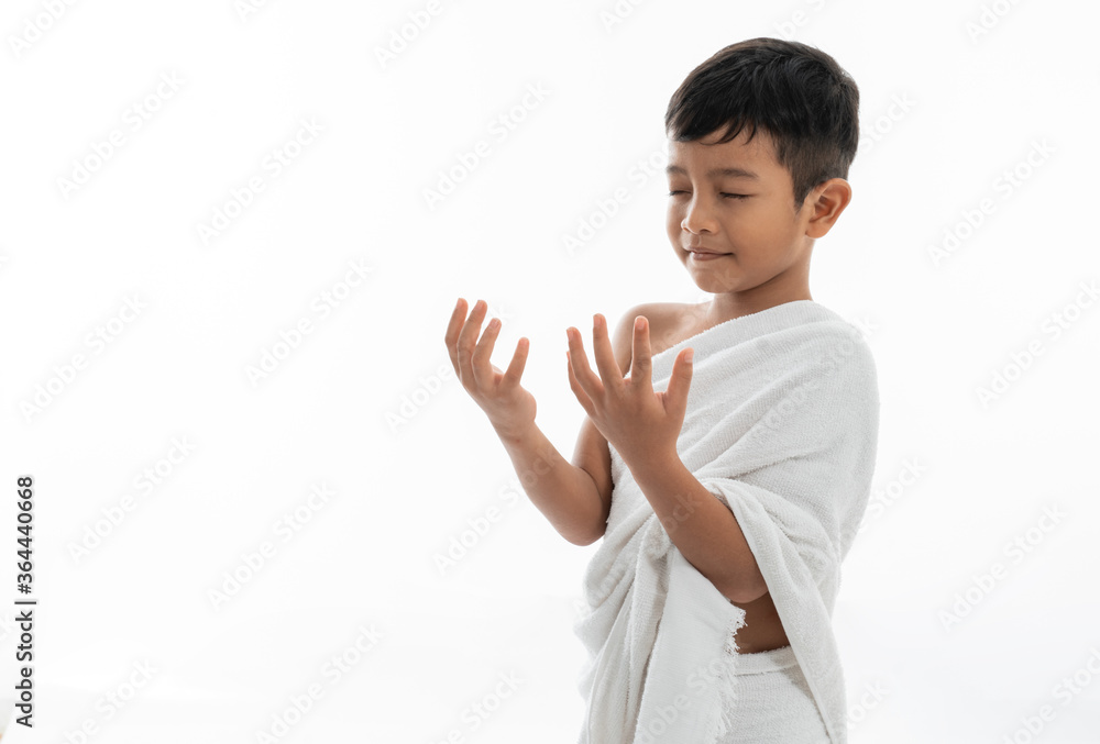 Muslim kid praying and wearing ihram isolated over white Muslim kid praying and wearing ihram isolated over white