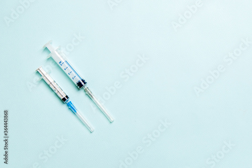 Top view of syringes in a row for medical injection on colorful background with copy space. Health and vaccination concept