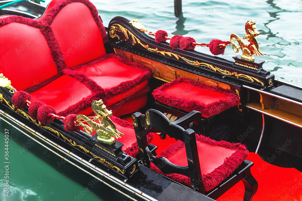 Venice gondola. Details of gondola on the water background. Traditional venetian boat decorated in red color and golden figured. Italy. Travel (vacation) concept.