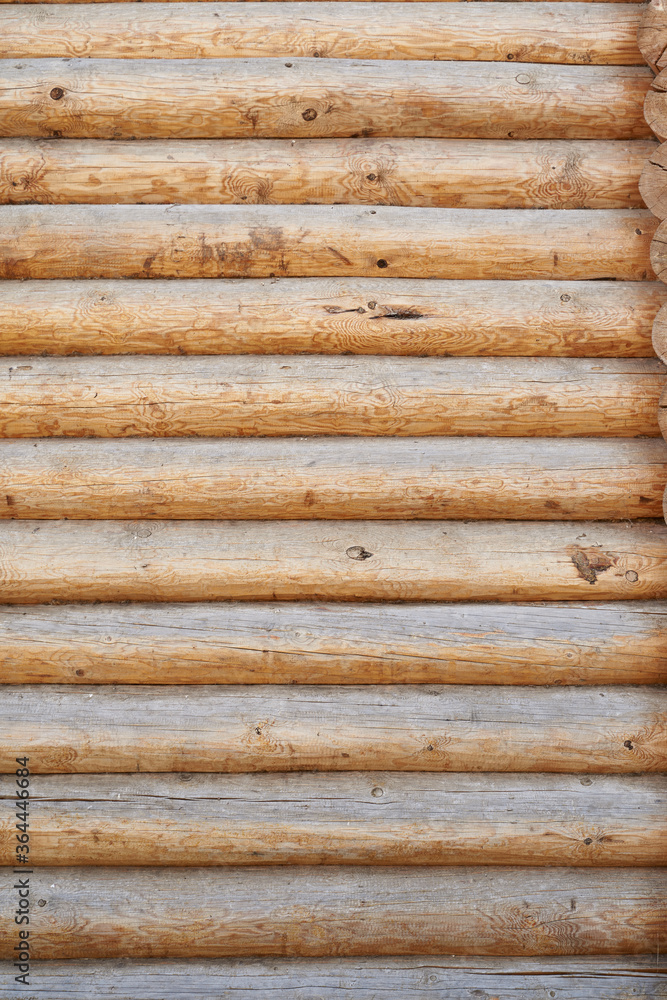 A wall made of natural wood of different sizes and shapes, Log house or barn, textured horizontal walls