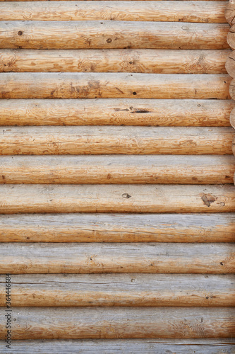 A wall made of natural wood of different sizes and shapes, Log house or barn, textured horizontal walls