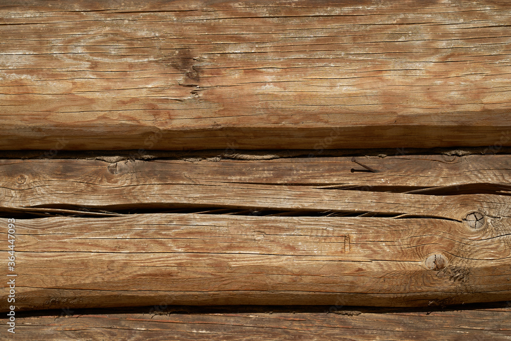 A wall made of natural wood of different sizes and shapes, Log house or barn, textured horizontal walls A wall made of natural wood of different sizes and shapes, Log house or barn, textured horizontal walls
