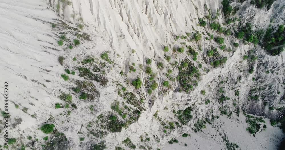 Beautiful, aerial view of a large, steep, natural quarry with a lonely tree on top of it. Beautiful, aerial view of a large, steep, natural quarry with a lonely tree on top of it.