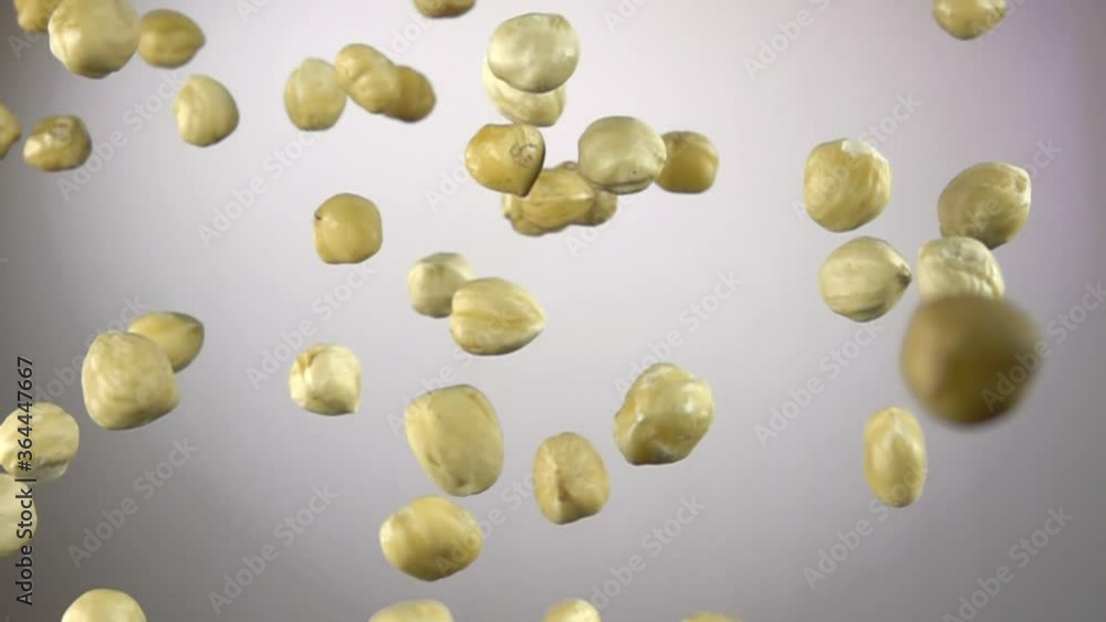 Close-up of Hazelnuts flying up on a white background in slow motion Close-up of Hazelnuts flying up on a white background in slow motion