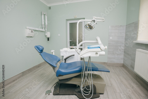 Modern dental practice. Dental chair and other accessories used by dentists in blue  medic light. Dentist Office  Dental Hygiene  Dentist s Chair