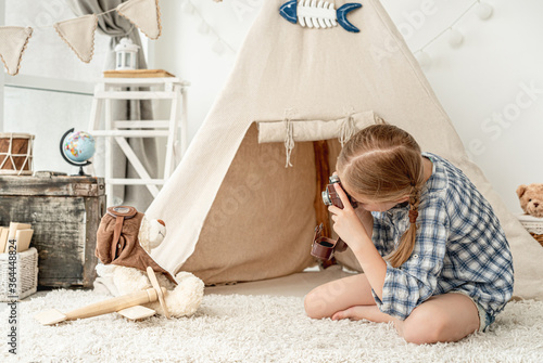 Nice little girl photographing plush teddy photo