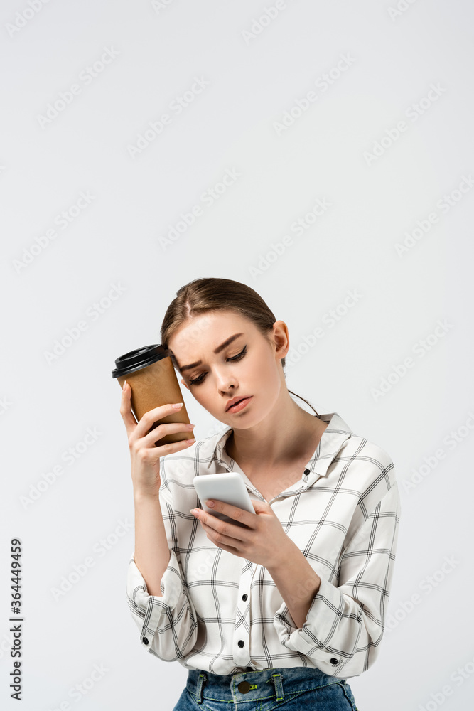 tired girl with smartphone and coffee to go isolated on grey