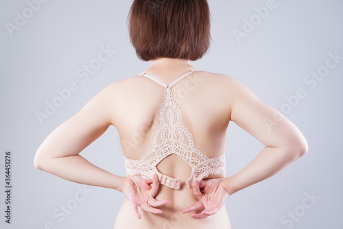 Woman undressing and unhooking her bra