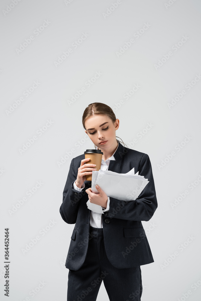 young businesswoman with coffee to go and papers isolated on grey young businesswoman with coffee to go and papers isolated on grey