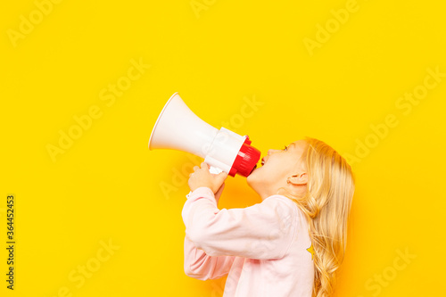 Kid shouting through vintage megaphone. Communication concept. Blue sky background as copy space for your text.