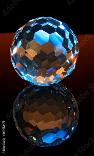 Faceted glass sphere on a black reflective surface