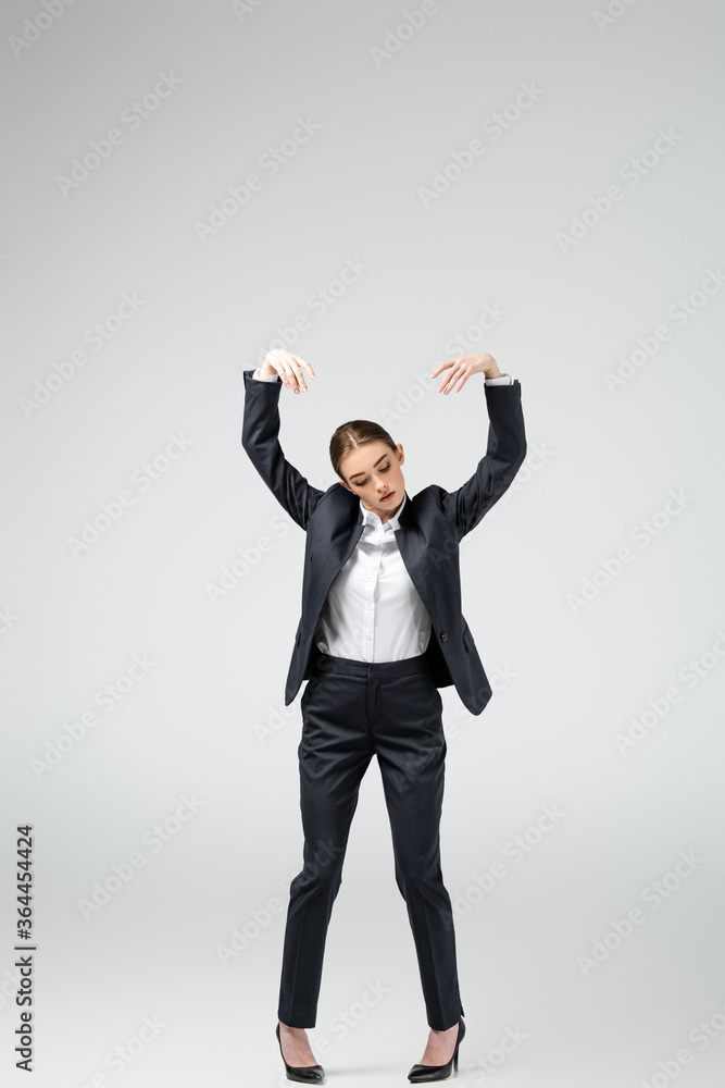 businesswoman marionette in suit posing isolated on grey businesswoman marionette in suit posing isolated on grey