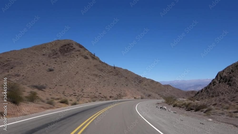 speeding down the winding and empty asphalt road in the middle of the desert, between mountains. POV shot speeding down the winding and empty asphalt road in the middle of the desert, between mountains. POV shot