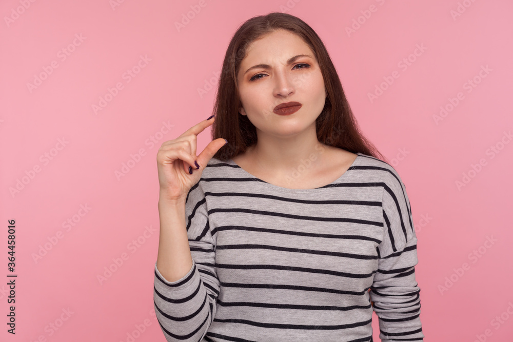 Very small amount! Portrait of woman disappointed with little size, showing minimum, low scale measurements and looking at camera with disappointment. indoor studio shot isolated on pink background Very small amount! Portrait of woman disappointed with little size, showing minimum, low scale measurements and looking at camera with disappointment. indoor studio shot isolated on pink background