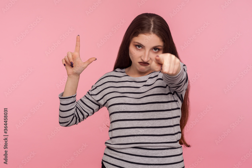 Hey, you lost! Portrait of angry bossy woman in striped sweatshirt showing L sign, loser gesture and pointing to camera, blaming for unsuccess, defeat. indoor studio shot isolated on pink background Hey, you lost! Portrait of angry bossy woman in striped sweatshirt showing L sign, loser gesture and pointing to camera, blaming for unsuccess, defeat. indoor studio shot isolated on pink background