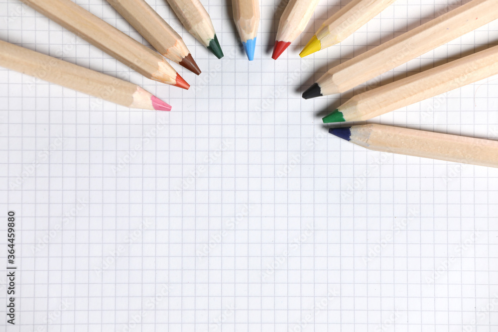 Obraz premium Flat lay view of white notebook , color pencils on a table. Preparing for a school. Back to school.