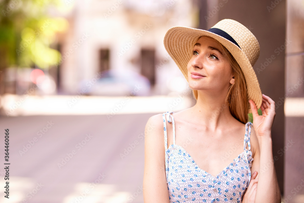 Attractive young woman portrait shot while wearing straw hat and smiling