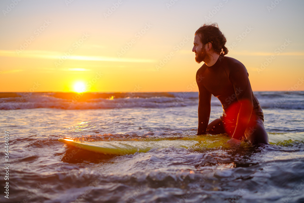 Surfer sitting on surfboard in sea Surfer sitting on surfboard in sea