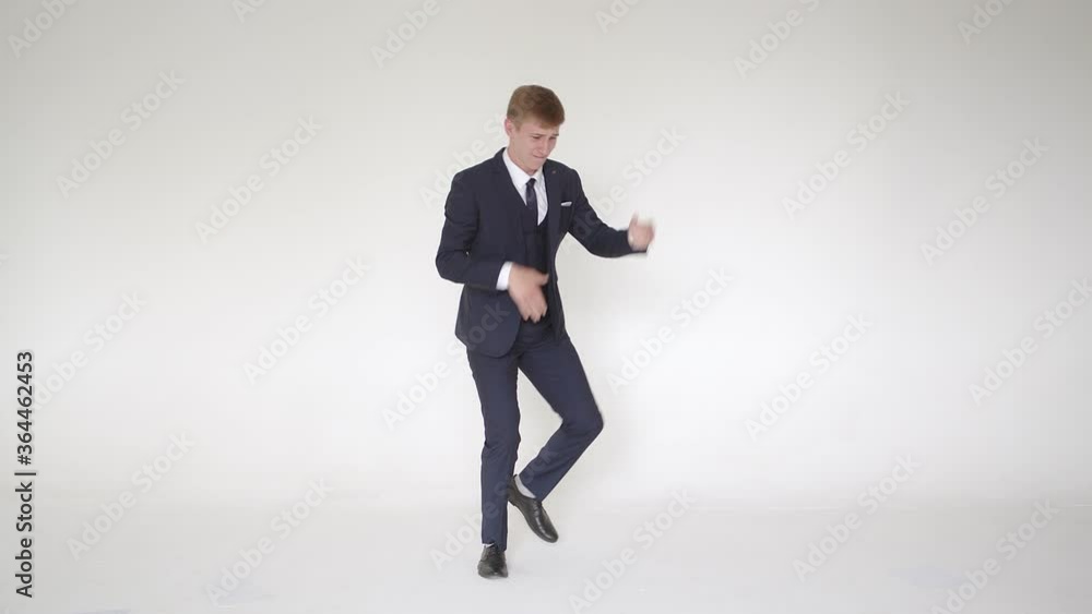 Enthusiastic, excited man, winner, dancing against a white background in the studio, laughing, celebrating job achievement, professional victory, happy, contented, business man enjoying a victory Enthusiastic, excited man, winner, dancing against a white background in the studio, laughing, celebrating job achievement, professional victory, happy, contented, business man enjoying a victory