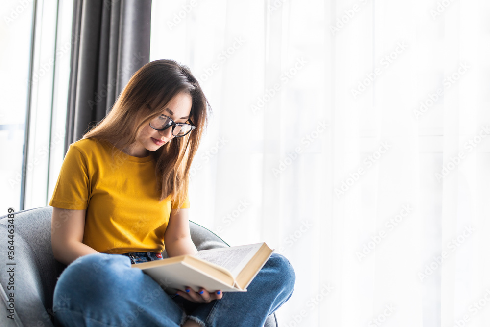Portrait beautiful young asian women read book on chair in living room area Portrait beautiful young asian women read book on chair in living room area
