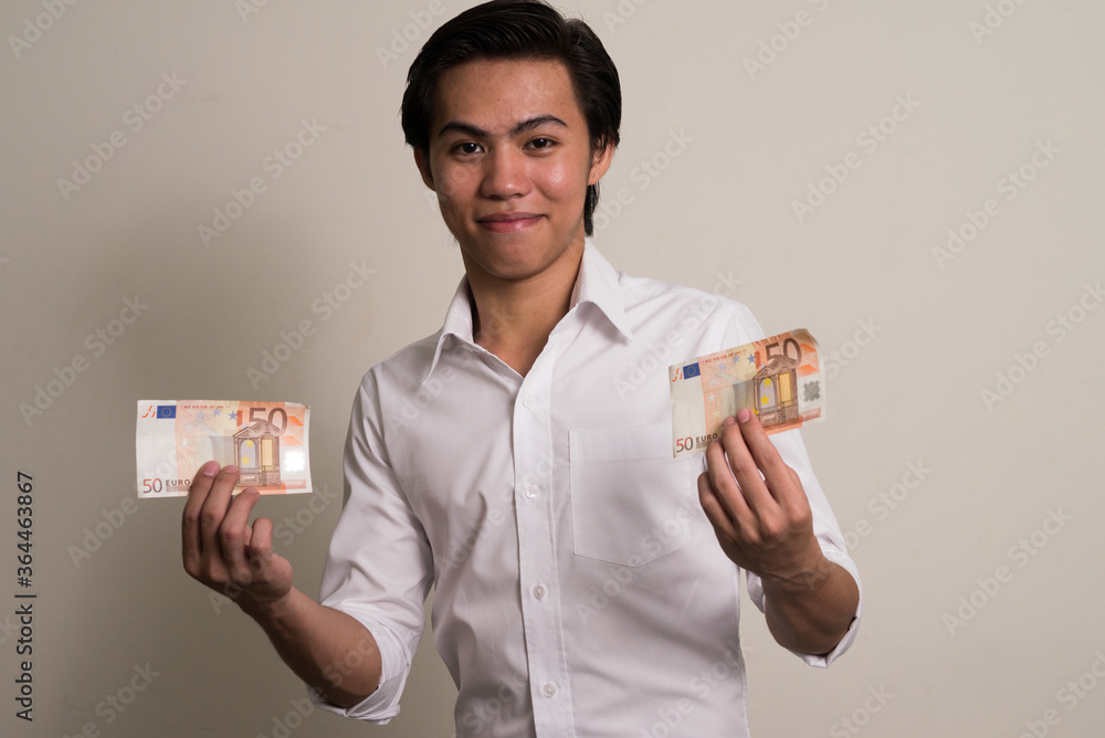 Portrait of young Filipino businessman holding money Portrait of young Filipino businessman holding money