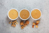 Peanut, walnut and almond butter on the gray concrete background