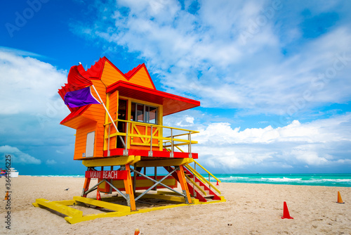 Orange, red and yellow lifeguard tower under a cloudy sky in South Beach © Gabriele Maltinti