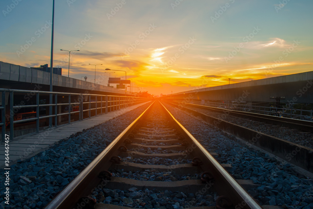 Fototapeta premium Railroad tracks and the orange light of the sunset