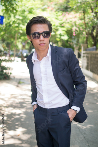 Portrait of young Filipino businessman in suit with sunglasses outdoors © Ranta Images