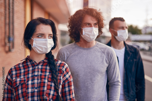 Group of young people in medical masks looking away