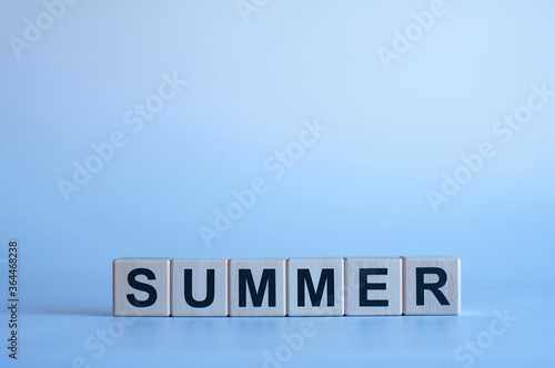 Summer. Black letters on wooden cubes. On a blue background