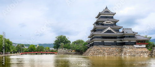 Matsumoto Castle is located in middle of water with red bridge to cross castle  which one of the historical sites in Japan. present it is a park and tourist attraction that has many tourists visiting.