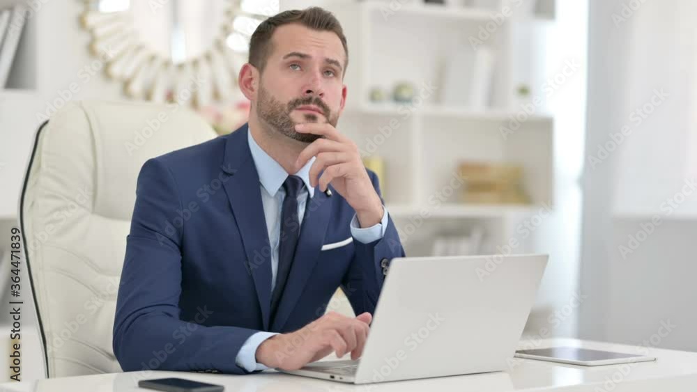 Businessman Thinking and working on Laptop in Office Businessman Thinking and working on Laptop in Office