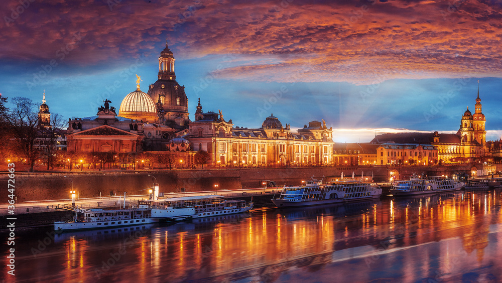 Fantastic colorful sunset in Dresden with dramatic sky, over the Elbe river. Old Town glowing in lighten reflected in calm water. Picturesque unusual scene. Creative image. Famouse Dresden buildings
