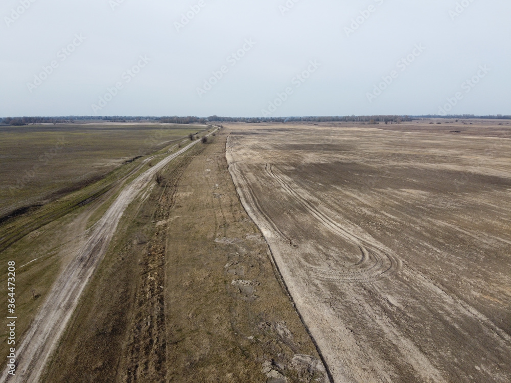 Dirt road in the fields, aerial view. Landscape. Dirt road in the fields, aerial view. Landscape.