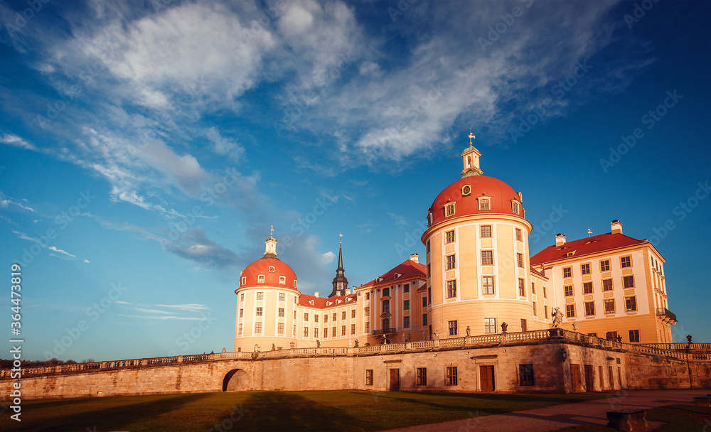 Famouse Moritzburg Castle near Dresden lit by the setting sun in the autumn. Saxony, Germany, Europe. Creative image. Awesome nature landscape with perfect sky. Popular Places for photographers.