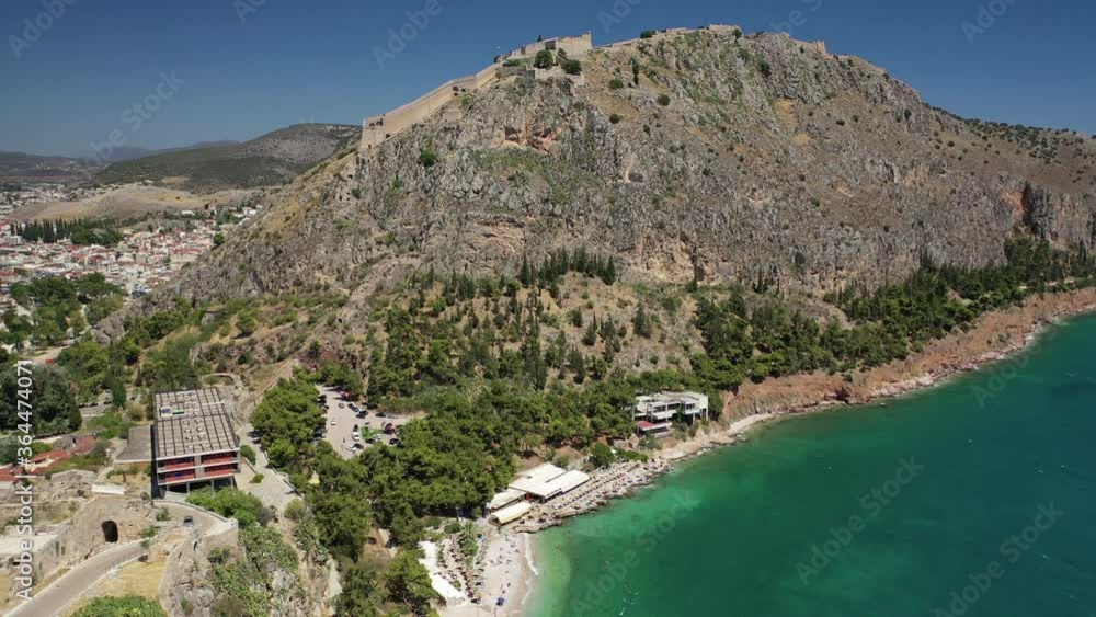 Aerial drone video of famous castle and beach of Arvanitia in the slopes of Acronafplia, Nafplio, Argolida, Peloponnese, Greece