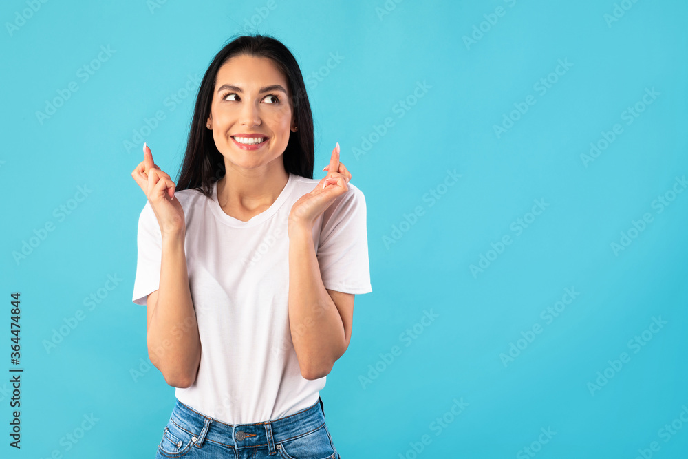Hopeful beautiful young girl crossing her fingers at studio Hopeful beautiful young girl crossing her fingers at studio