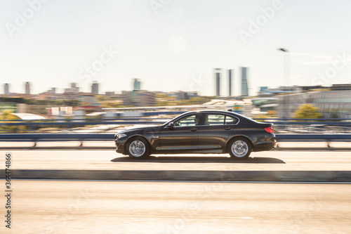 Coche de alta gama pasando por una carretera con la ciudad de Madrid y su skyline al fondo © Gregorio