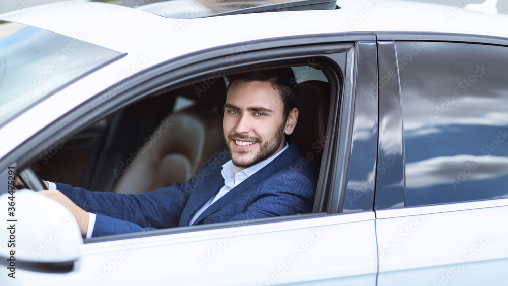 Happy CEO sitting on driver's seat of his car, going to work at big city Happy CEO sitting on driver's seat of his car, going to work at big city