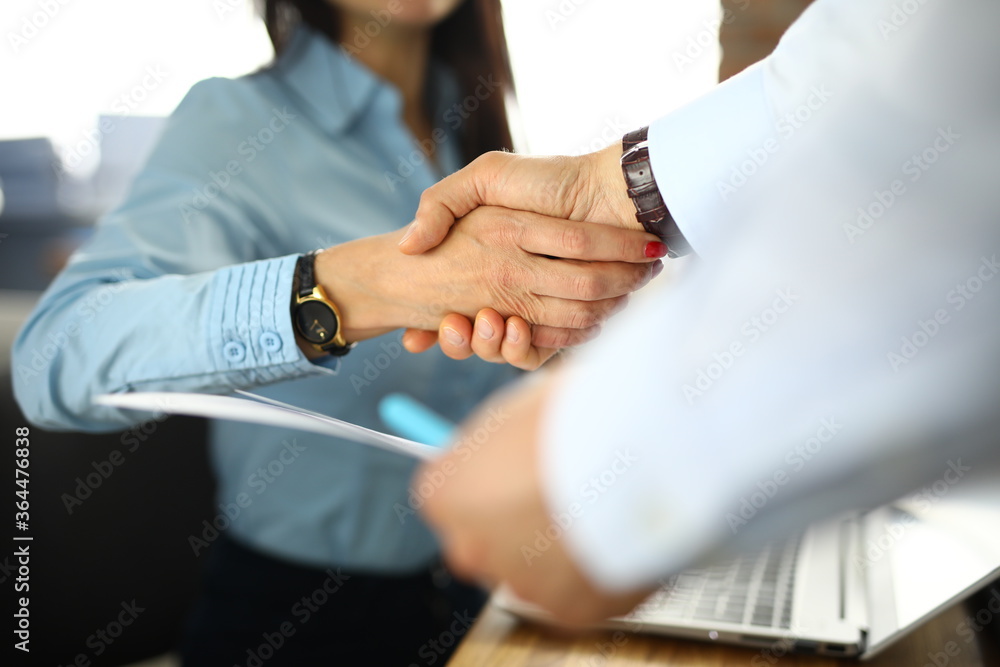 Business woman in office shakes hands with man. Successful teamwork concept