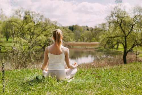 Wallpaper Mural A girl meditates in the Lotus position in the fresh air in the Park. The girl relaxes after yoga. Back view, space for text Torontodigital.ca