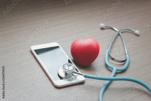 Doctor online concept, red heart with stethoscope and smartphone for online consultation with patient, online medical communication on virtual interface, virtual hospital