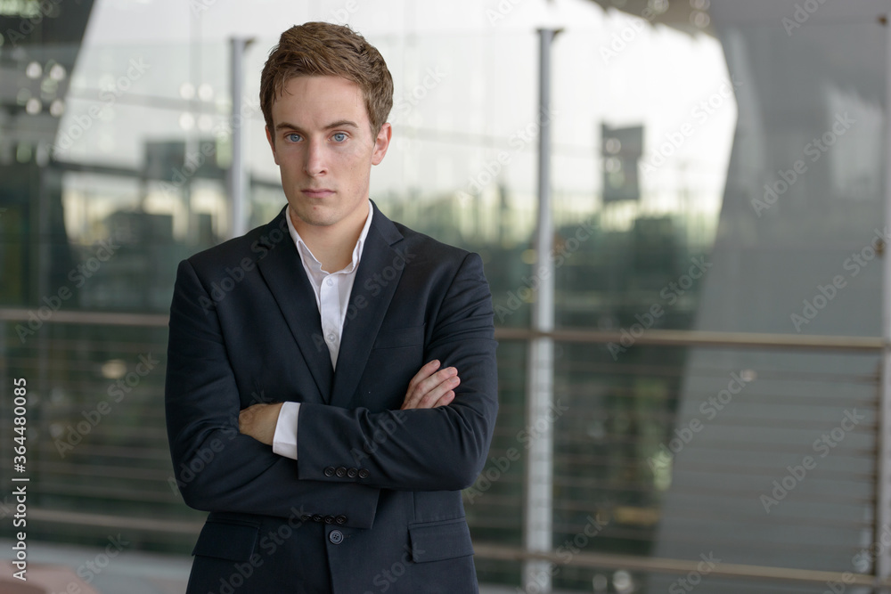 Portrait of young handsome businessman with arms crossed at the airport Portrait of young handsome businessman with arms crossed at the airport