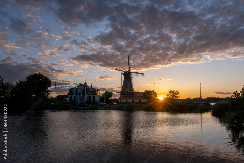 Sundown with Dutch windmill in the waters of Kralingse Plas, Rotterdam