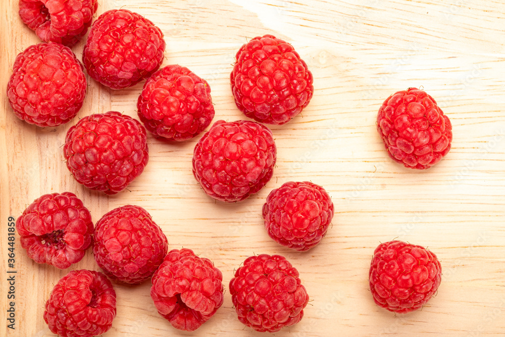Fresh ripe raspberries on a wooden plate. Fresh ripe raspberries on a wooden plate.