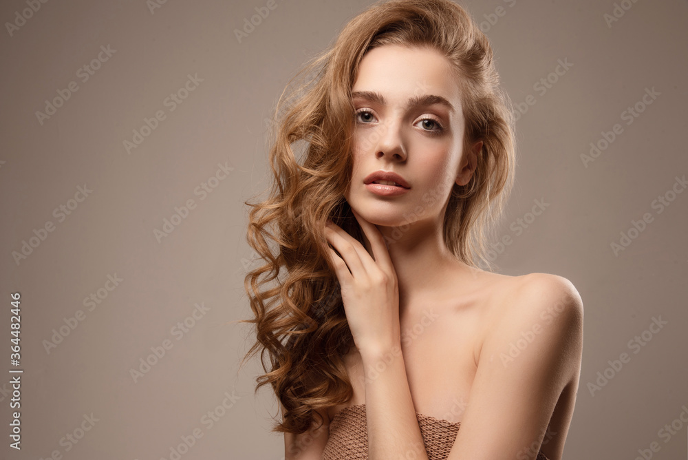 Naklejka premium Young woman with perfect skin. Studio portrait. Natural nude makeup. Girl with beautiful hair.