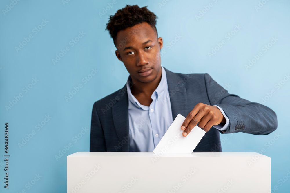 Concentrated african american businessman pulling paper in vote ballot
