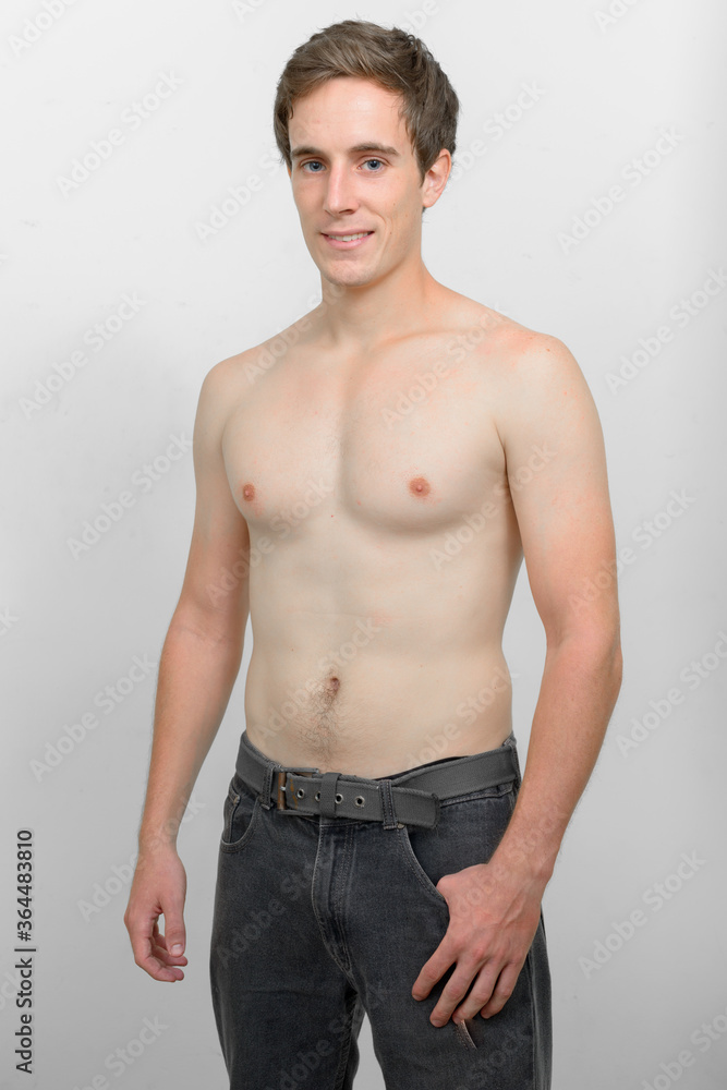 Portrait of happy young handsome man smiling shirtless